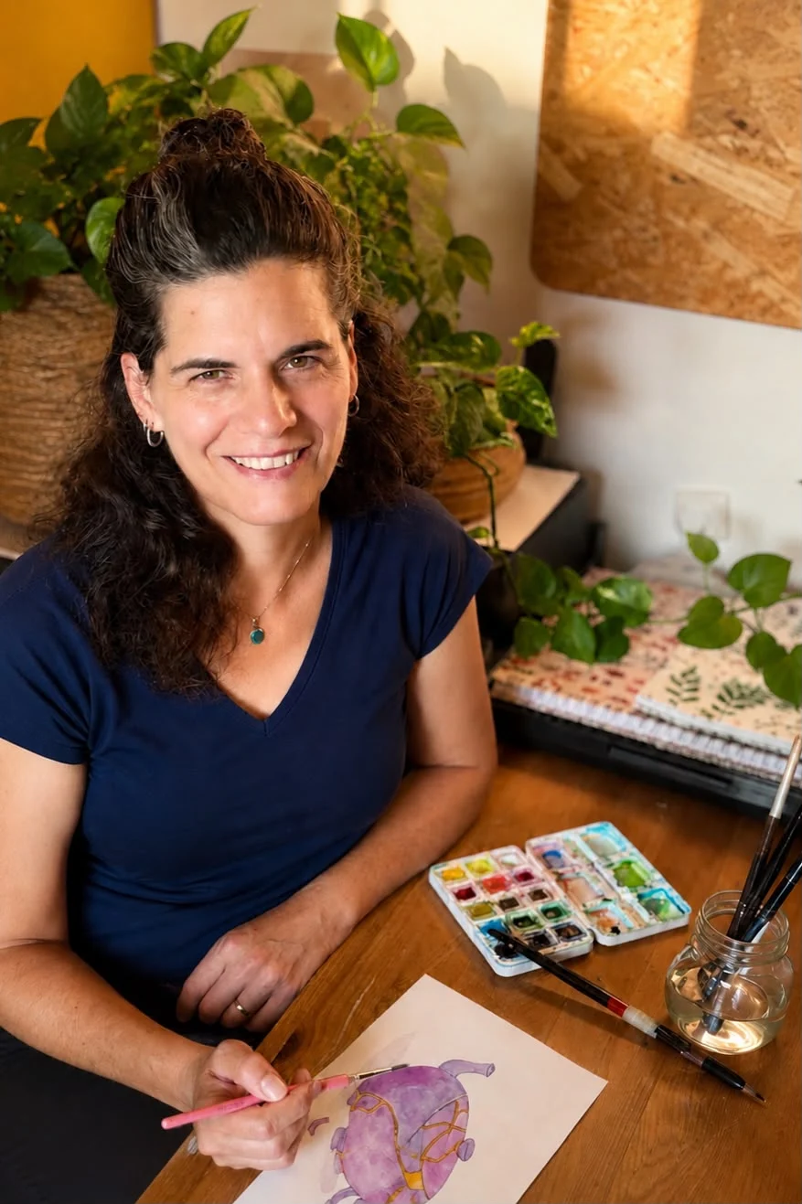 גילי שחר בסטודיו שלה, מציירת בצבעי מים